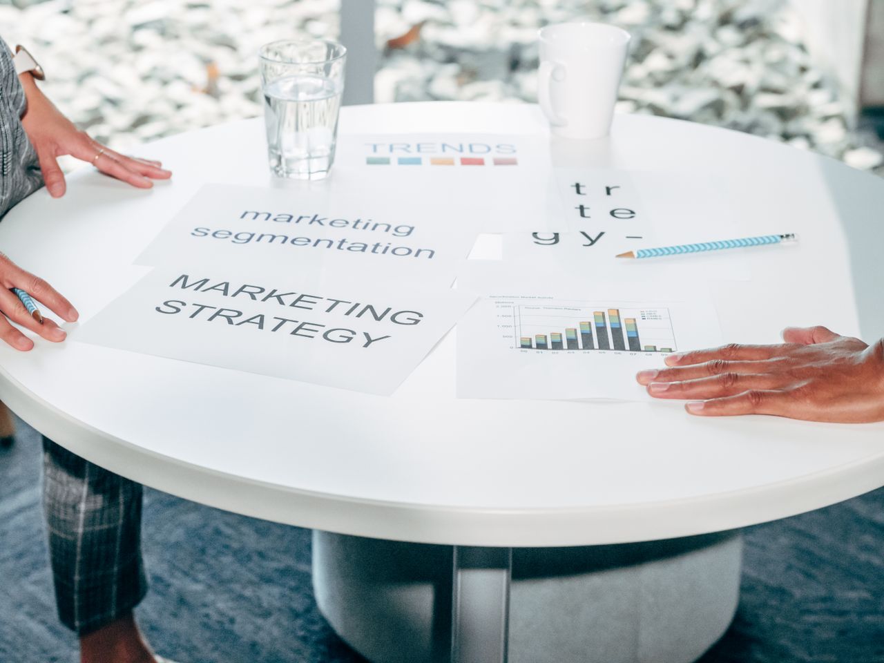 why-choose-us Two professionals collaborate on marketing strategy and segmentation at a round table.